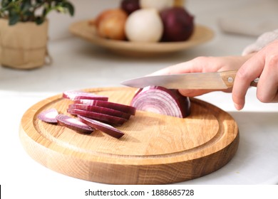 Woman cutting red onion into slices at countertop in kitchen, closeup - Powered by Shutterstock