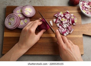 Woman cutting red onion on wooden board at grey table, above view - Powered by Shutterstock