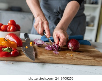 Woman is cutting red onions into slices on a cutting board - Powered by Shutterstock