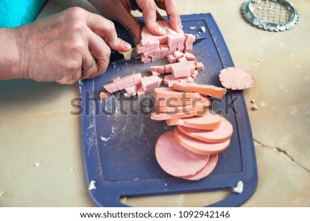 woman cutting a sausage