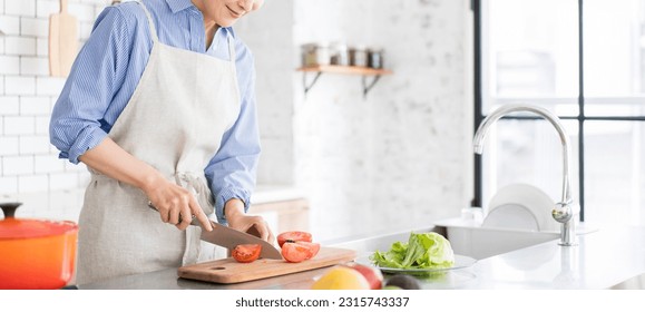 A woman is cutting vegetables in the kitchen. - Powered by Shutterstock