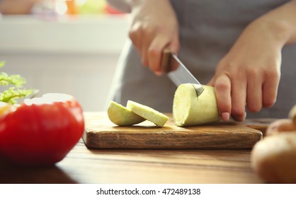 Woman Cutting Vegetables On Kitchen