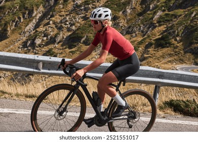 Woman in cycling gear rides her bike on a winding mountain road. Image captures the thrill and beauty of outdoor cycling. Cycling in Carpathian Mountains. Sports motivation image.Empty mountain road. - Powered by Shutterstock