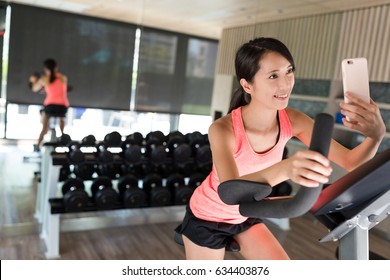 Woman Cycling And Taking Selfie In The Gym Room 