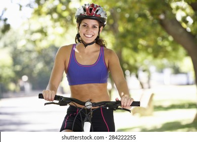 Woman Cycling Through Park