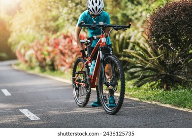 Woman cyclist adjust the seat height cycling on summer park trail - Powered by Shutterstock