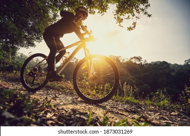 Woman cyclist cycling on sunrise winter forest trail - Powered by Shutterstock