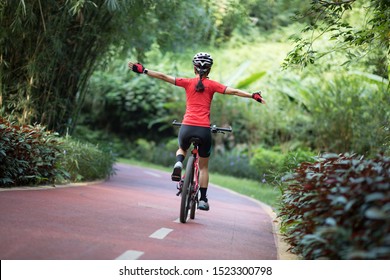 Woman cyclist riding mountain bike on tropical rainforest trail - Shutterstock ID 1523300798
