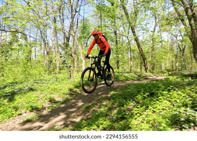 Woman cyclist riding a mountain bike on a nature trail. Living a healthy lifestyle.  - Powered by Shutterstock