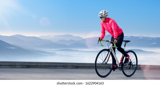 Woman Cyclist Riding Road Bike On The Mountain Road At Sunny Morning. Adventure, Travel, Healthy Lifestyle And Sport Concept.