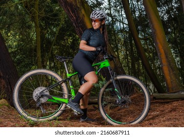 Woman Cyclist Stopped In A Forest While Looking Back