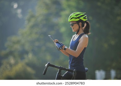 Woman cyclist using mobile phone in summer park   - Powered by Shutterstock