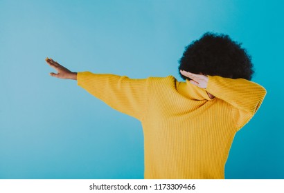 Woman Dabbing On Colored Backgrounds. Young Adult With Afro Haircut Making The Dab Move