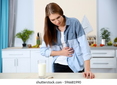 Woman With Dairy Allergy And Glass Of Milk On Table