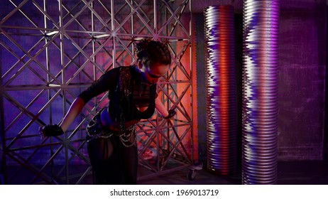 A Woman Dances A Modern Dance In A Darkened Studio, She Is Dressed In A Revealing Suit With An Open Stomach And Is Illuminated By Light. Makes Movements With His Hands And Body.