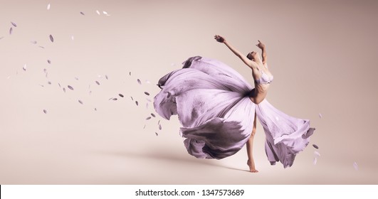 Woman Dancing In Flowing Purple Dress In Studio