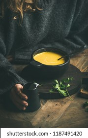 Woman In Dark Grey Winter Sweater Eating Sweet Corn And Shrimp Chowder Soup From Black Bowl. Autumn Or Winter Warming Food