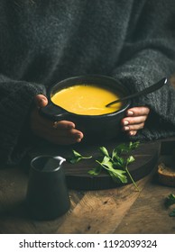 Woman In Dark Grey Woolen Winter Sweater Eating Sweet Corn And Shrimp Chowder Soup From Black Bowl. Autumn Or Winter Warming Food