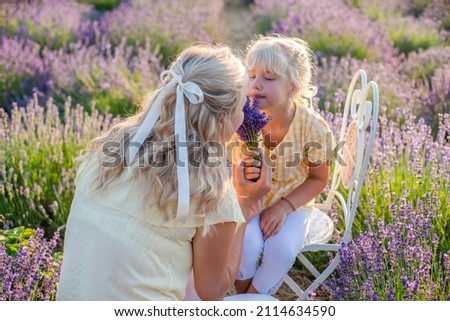 woman with daughter on lavender field happy on warm summer day. 