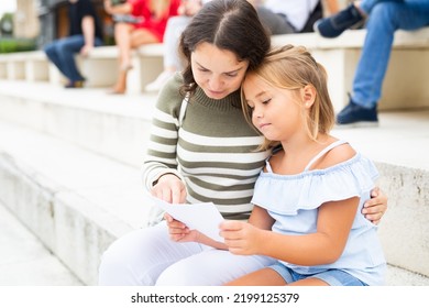 Woman And Daughter Sitting On Stone Stairs In Barcelona City Center