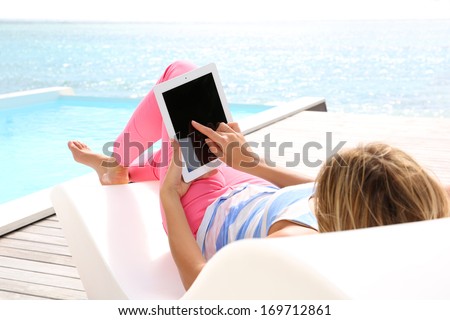 Woman in deckchair using digital tablet