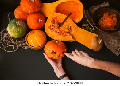 woman decorates a pumpkin to celebrate halloween - Shutterstock ID 710293888