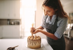 Woman Decorating Chocolate Cake In The Kitchen. Female Chef Making A Cake At Home.