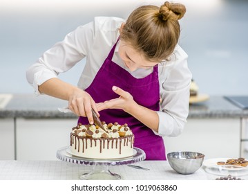 Woman Decorating Chocolate Cake In The Kitchen