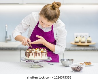 Woman Decorating Chocolate Cake In The Kitchen