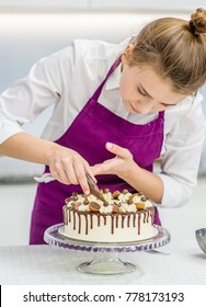 Woman Decorating Chocolate Cake In The Kitchen