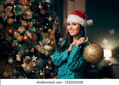 Woman Decorating Christmas Tree With Sparking Ornament. Party Host Preparing For Holidays Decorating The House