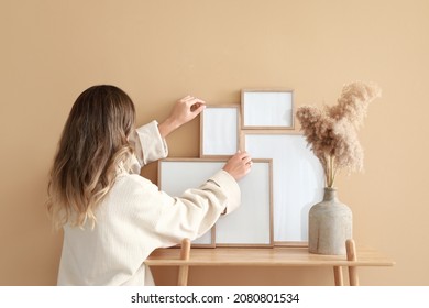 Woman decorating room with photo frames