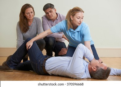 Woman Demonstrating Recovery Position In First Aid Training Class