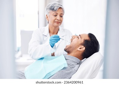 Woman, dentist and check teeth of man with tools for dental cosmetics, healthcare assessment and medical consulting. Patient, tooth and oral cleaning with mirror, excavator and orthodontic surgery - Powered by Shutterstock