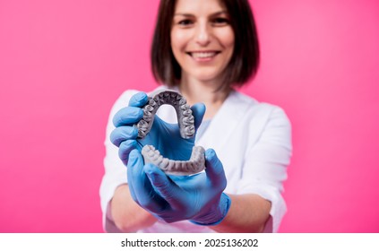 Woman dentist holds in hands dental gypsum models