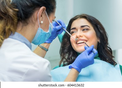 Woman at the dentist smiling. Work of stomatologist with patient. Make your smile perfect. - Powered by Shutterstock