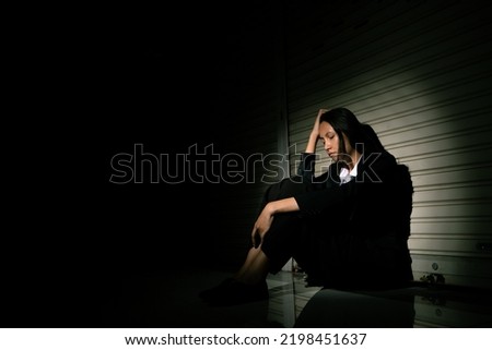 Woman depressed from sad stress pain despair problem, person sit on closed shop on corridor alone with emotion lonely desperate upset head down. Head in hand no way out concept, copy space