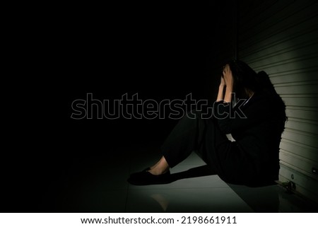 Woman depressed from sad stress pain despair problem, person sit on closed shop on corridor alone with emotion lonely desperate upset head down. Head in hand no way out concept, copy space