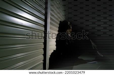 Woman depressed from sad stress pain despair problem, person sit on closed shop on corridor alone with emotion lonely desperate upset head down. Black Dark Underexposure concept, copy space