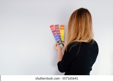 Woman designer or architect choosing wall color from color palette
