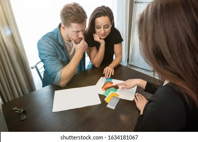 woman designer consulting young couple husband and wife on wall colours using color palette sitting in new apartment. - Powered by Shutterstock