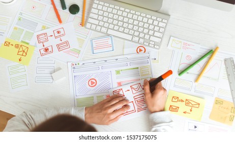Woman designer creates a website layout. The designer draws a user interface. Website development on the desktop.