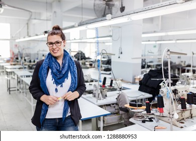 Woman designer posing in textile factory.