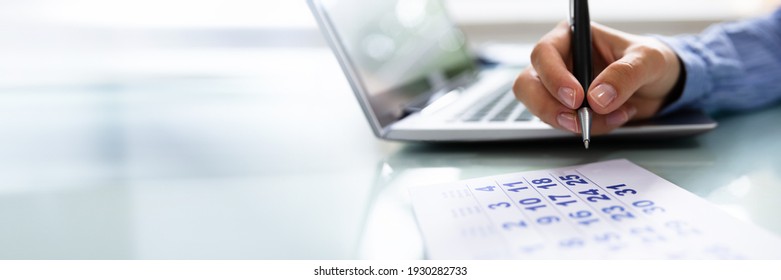 Woman At Desk Arranging Holiday Days In Calendar