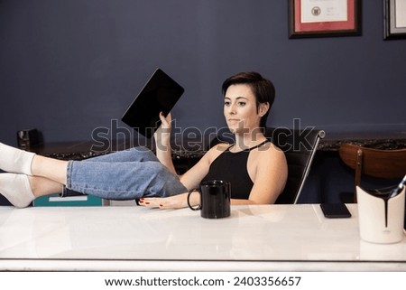 woman at desk in office working on tablet