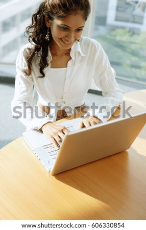 Woman at desk, using laptop