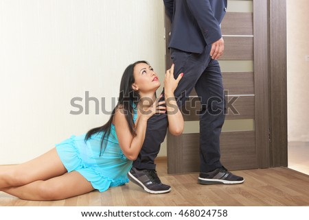 Woman desperately clinging to the leg of a man
