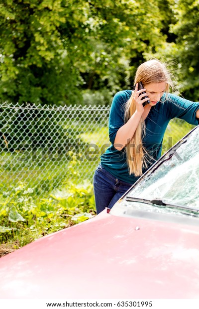 Woman dialing her phone\
after car crash