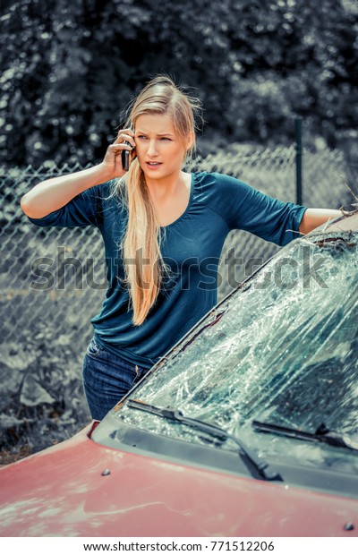 Woman dialing her phone\
after car crash