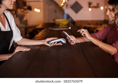 Woman Dialing The Secret Code To Do A Contactless Payment By Phone Using NFC Technology. Paying With Just A Tap In A Coffee Shop During Daytime. Concept Technology Contactless.